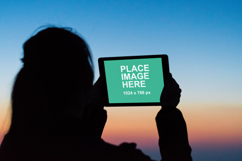Woman using iPad at dusk
